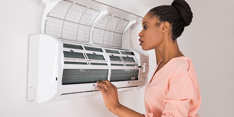 Woman checking AC unit